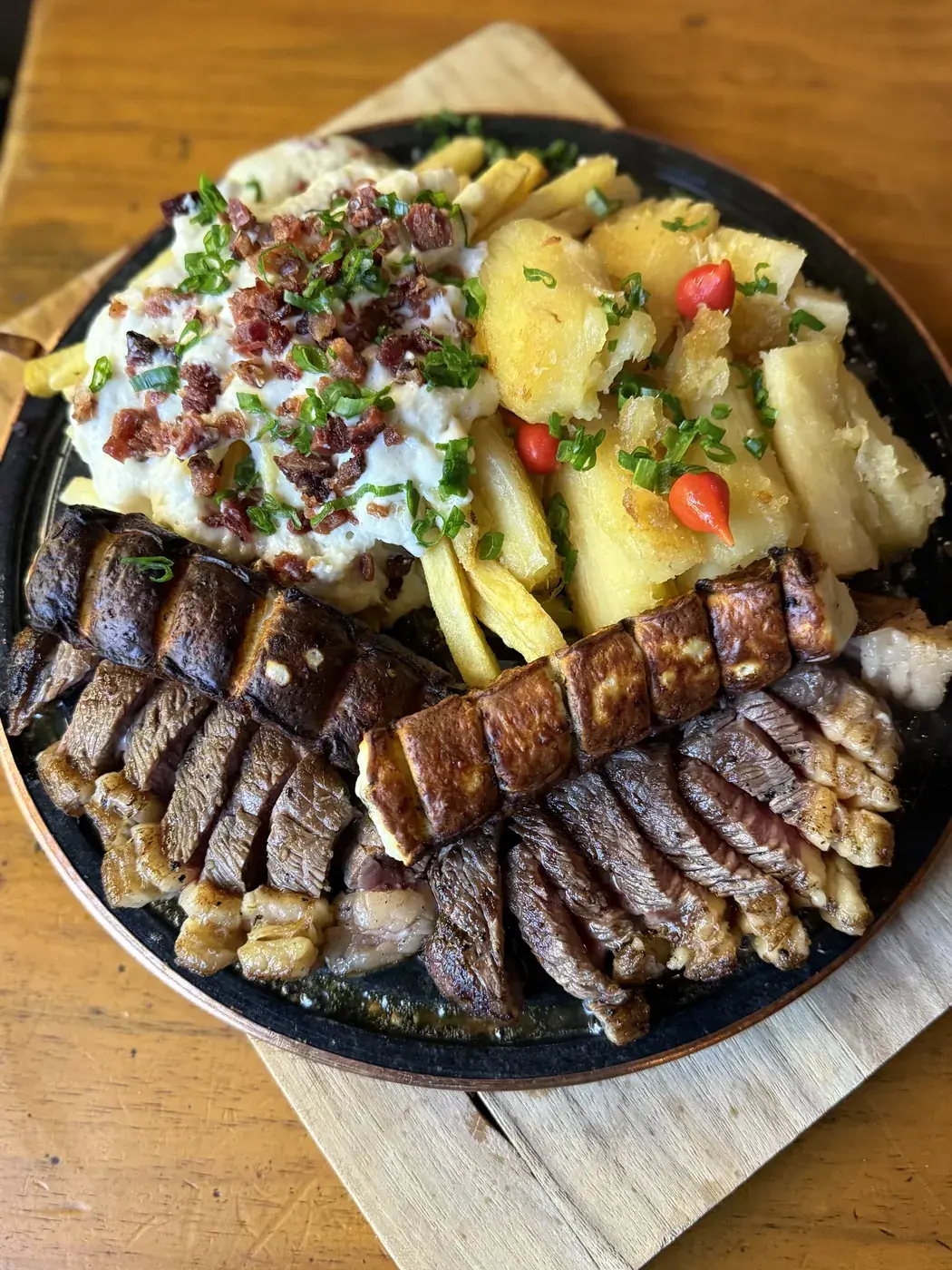 Chapa com carnes, aipim na manteiga e batata com queijo e bacon
